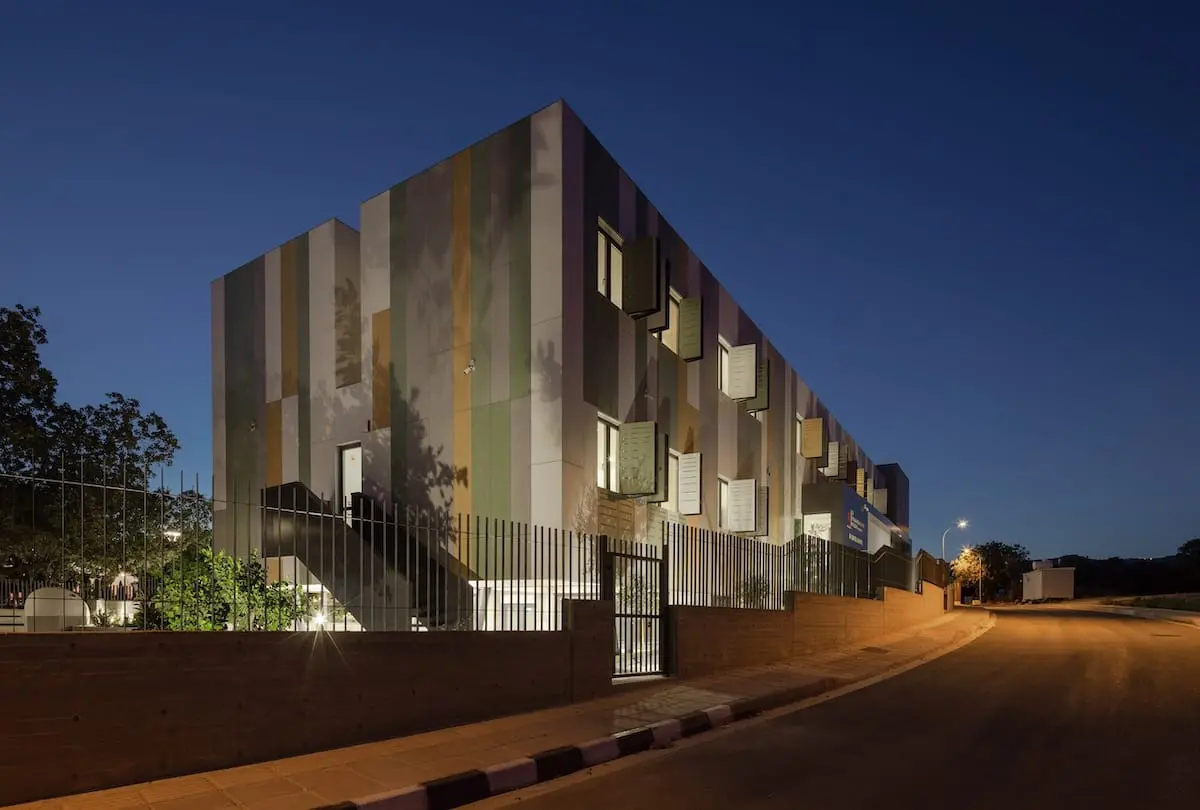 ulticolored fiber cement facade on residential building at night, highlighting design flexibility and weather-resistant performance in real-world architecture.