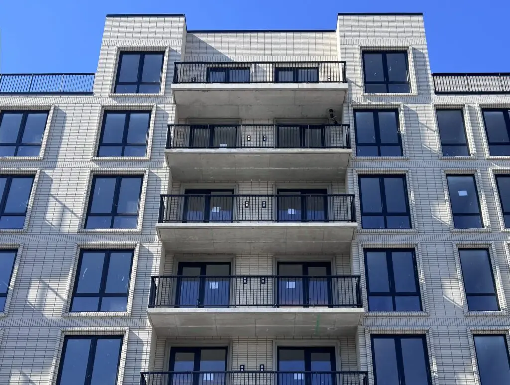 Multi-story residential building with repeating balconies and a consistent facade system designed for durability and long-term performance