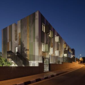 Ulticolored Fiber Cement Façade On Residential Building At Night, Highlighting Design Flexibility And Weather-resistant Performance In Real-world Architecture.