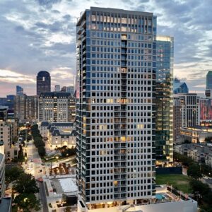High-rise Building In A Dense Urban Skyline At Dusk, Representing Sustainable Design Challenges In City Environments.