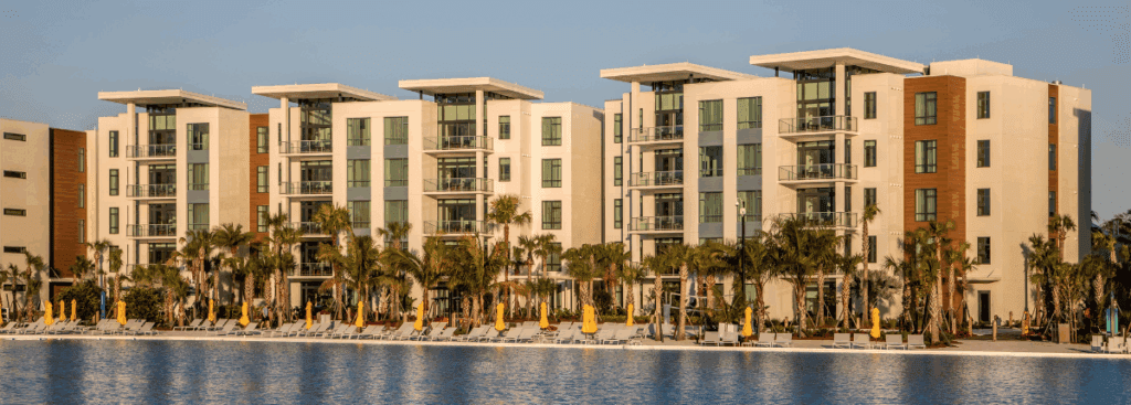 Waterfront multifamily building with light-colored facade designed for long-term exterior durability