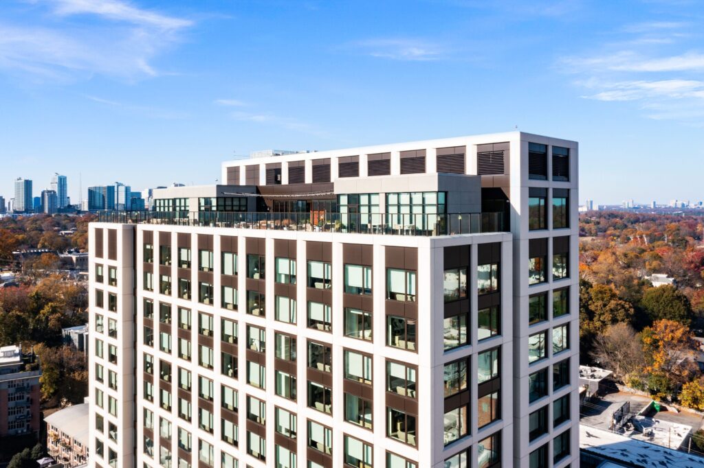 Multi-story residential high-rise building exterior with a mix of glass and metal panel facade